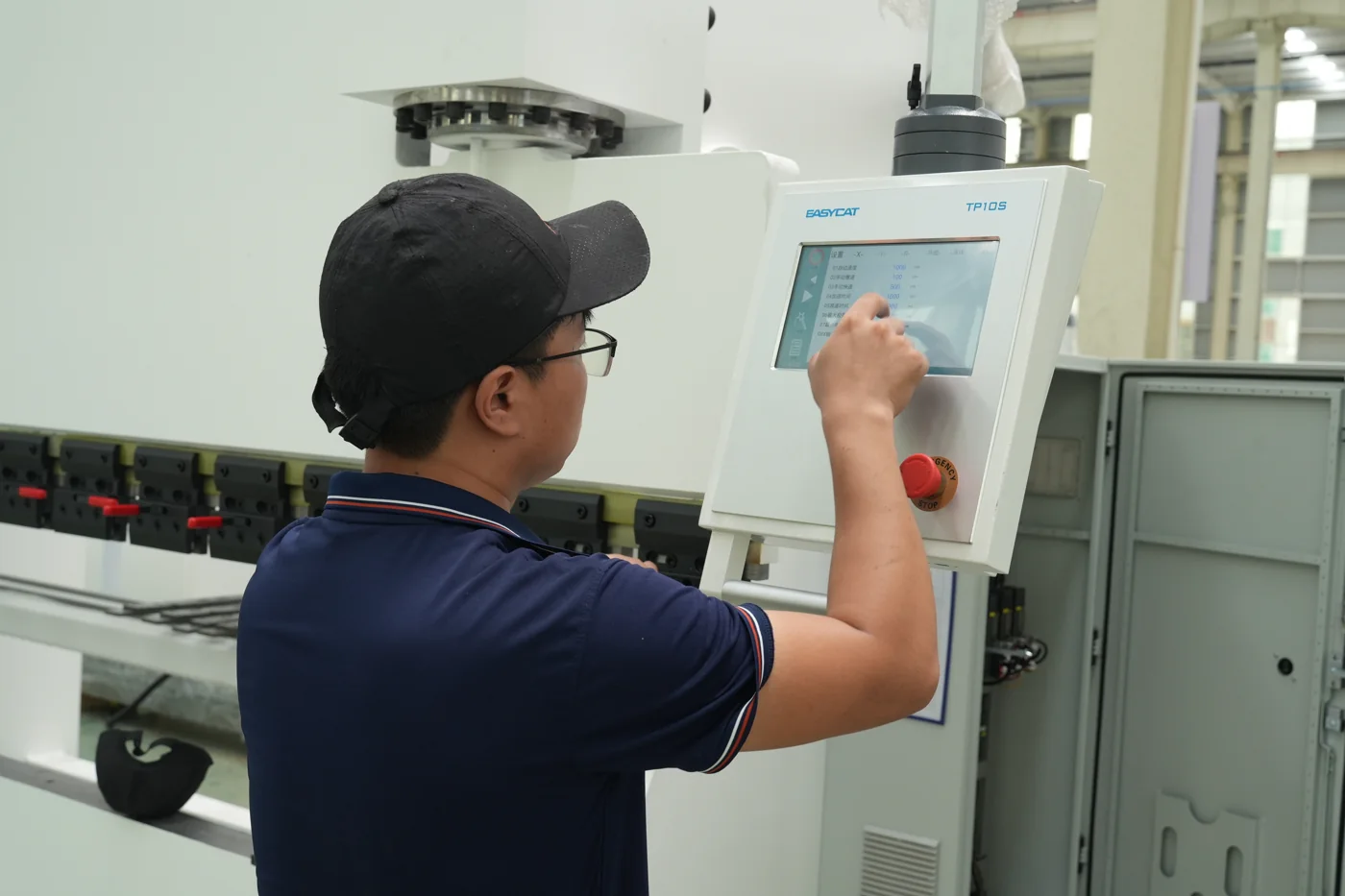 Operator mengatur panel kontrol mesin bending